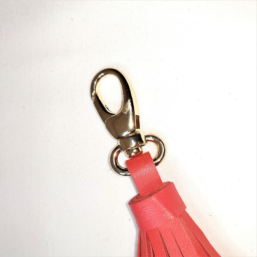 Jóia de bolsa com pompom de pele de cordeiro em cor-de-laranja vermelha.