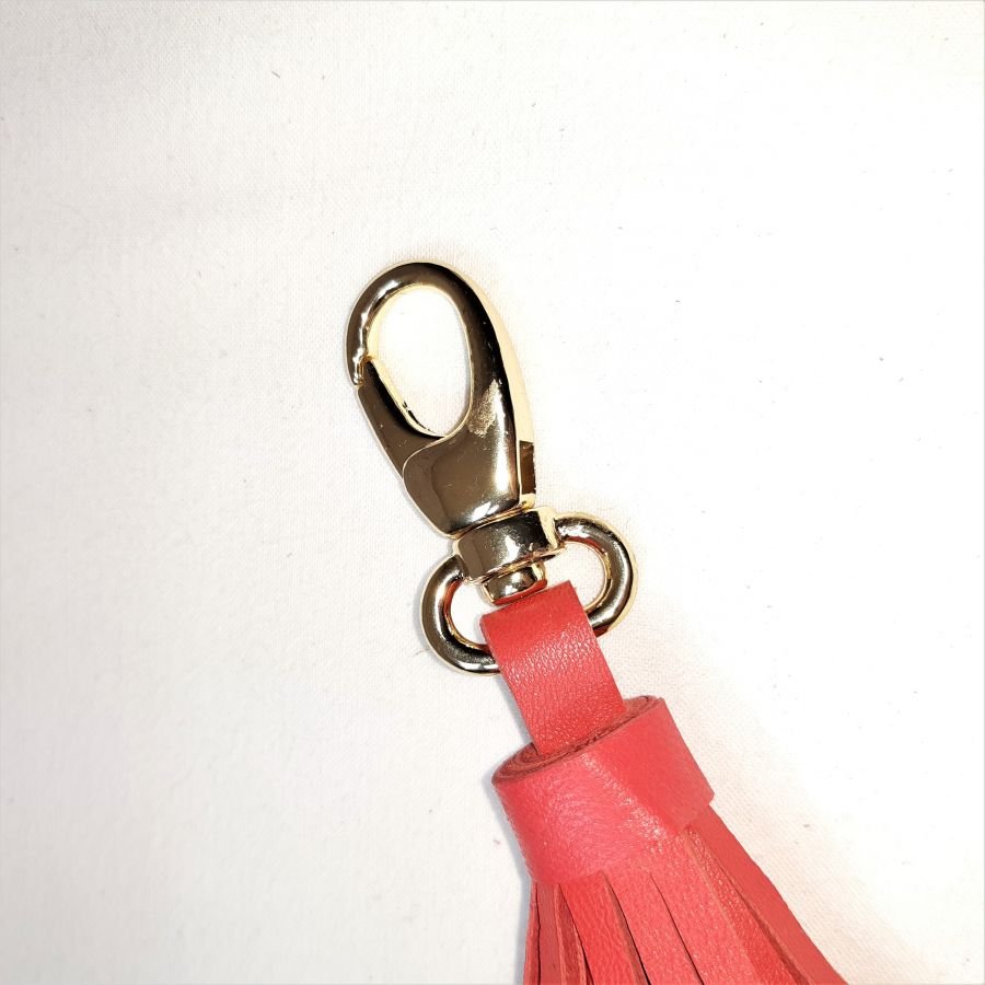 Jóia de bolsa com pompom de pele de cordeiro em cor-de-laranja vermelha.