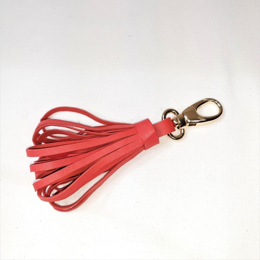 Jóia de bolsa com pompom de pele de cordeiro em cor-de-laranja vermelha.