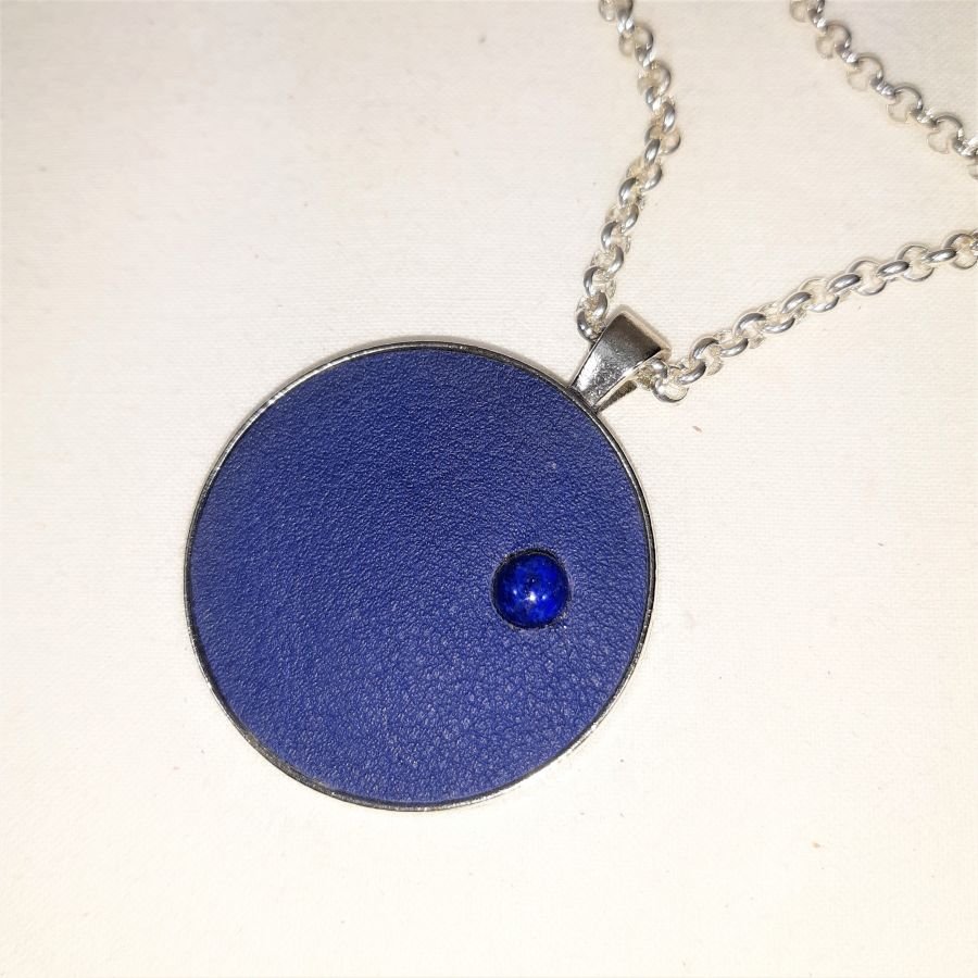 Pendente de latão e couro azul com cabochão de lápis lazúli.