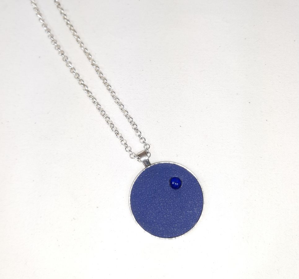 Pendente de latão e couro azul com cabochão de lápis lazúli.