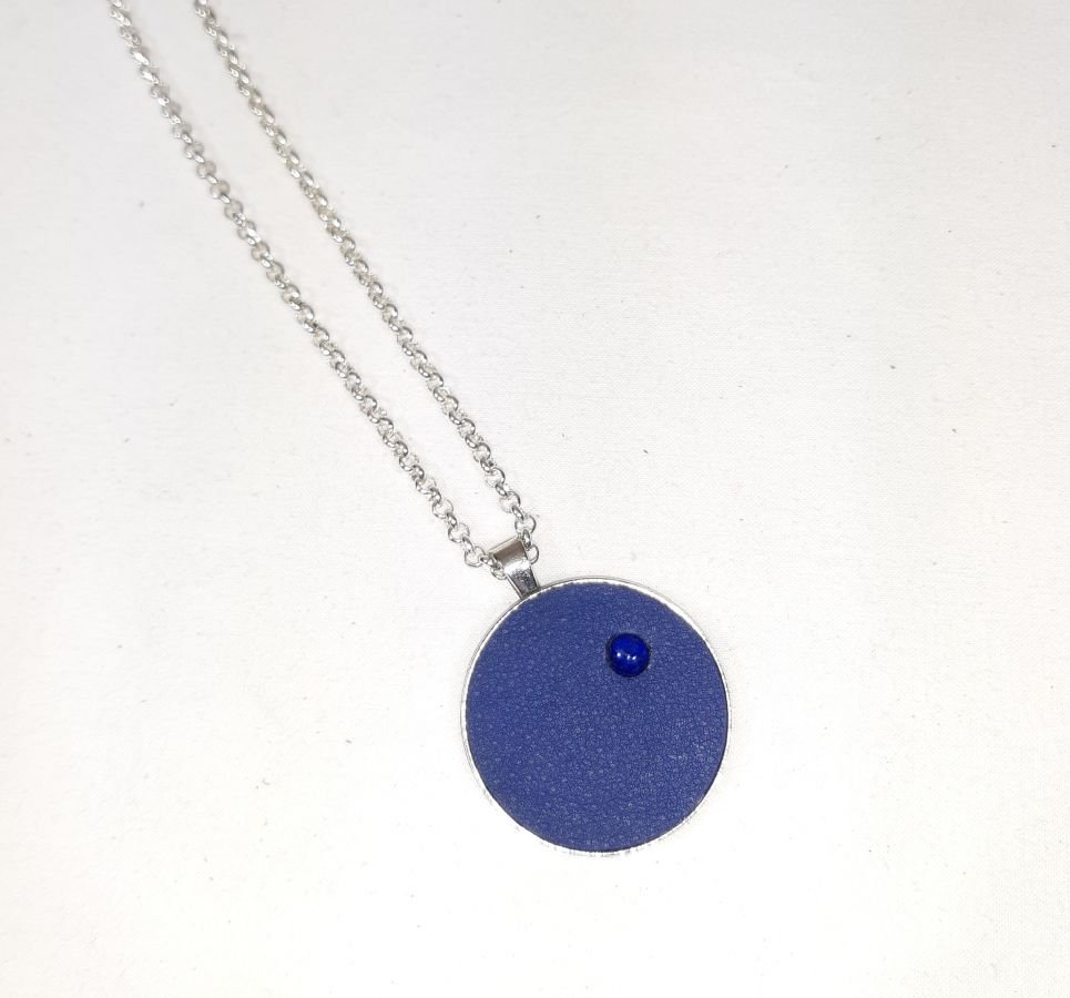 Pendente de latão e couro azul com cabochão de lápis lazúli.
