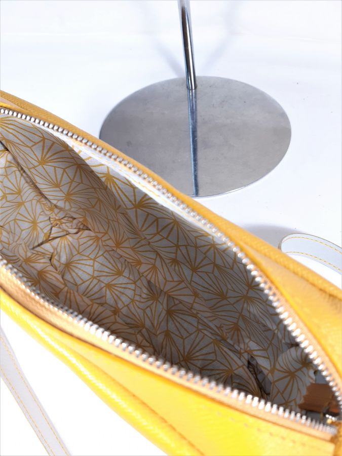 Saco de couro de grão inteiro com fecho amarelo.