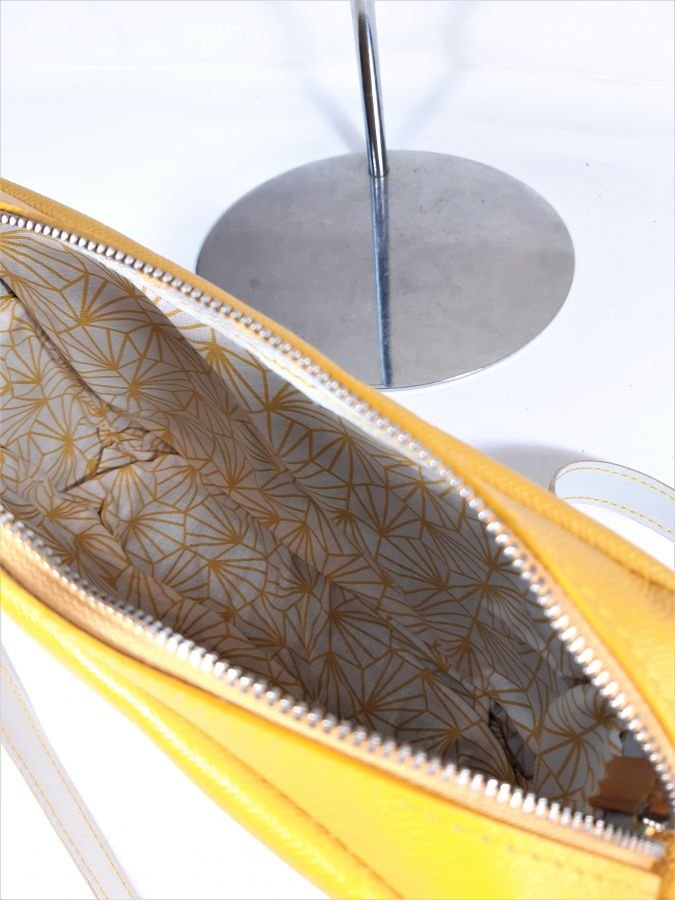 Saco de couro de grão inteiro com fecho amarelo.
