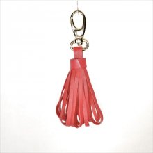 Jóia de bolsa com pompom de pele de cordeiro em cor-de-laranja vermelha.